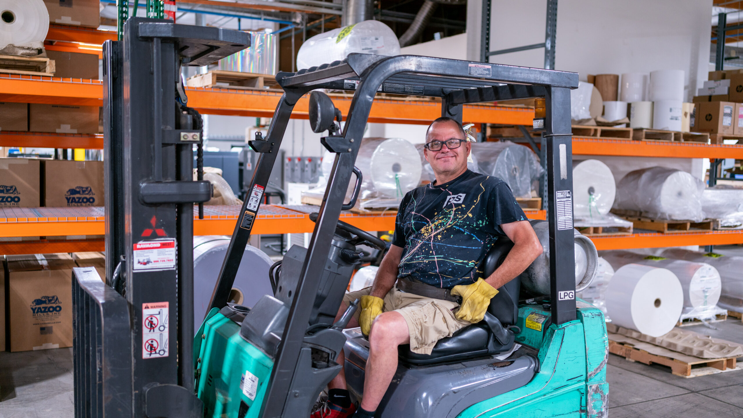 Smiling PS employee sitting in a forklift