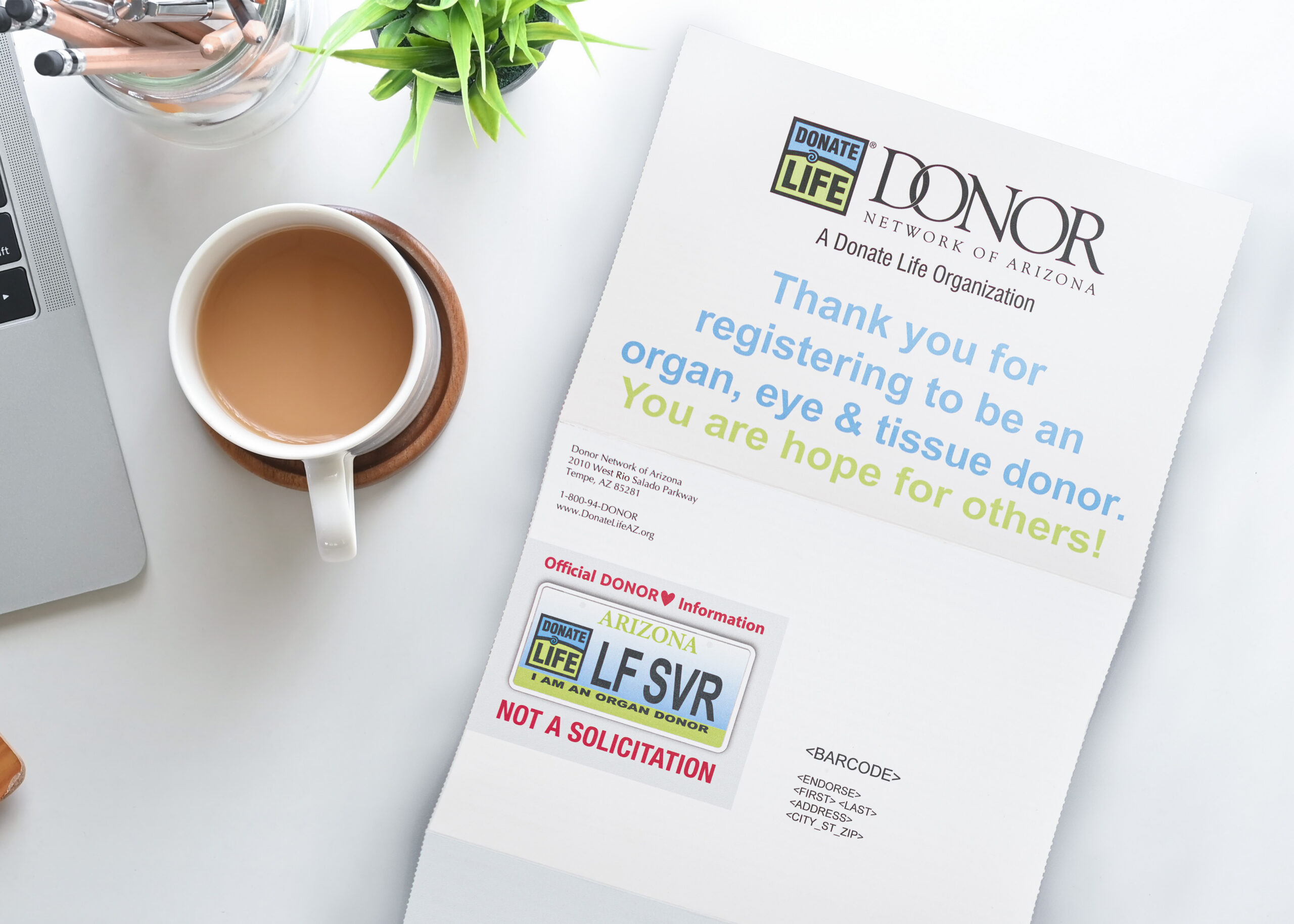 Donor Network opened direct mail from above next to a cup of coffee