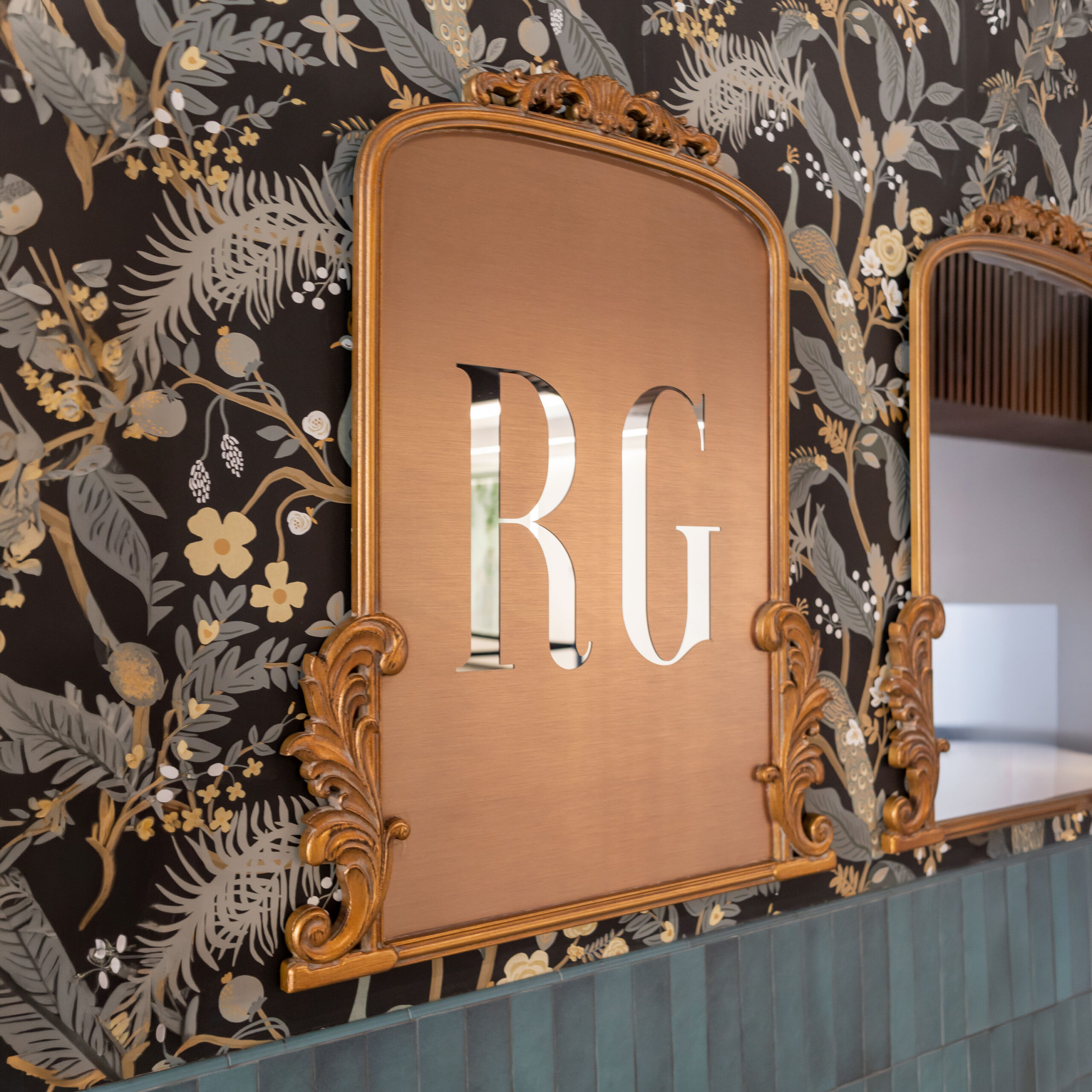 Rose Garden ornate mirror with die cut vinyl monogram hung on a floral patterned wall