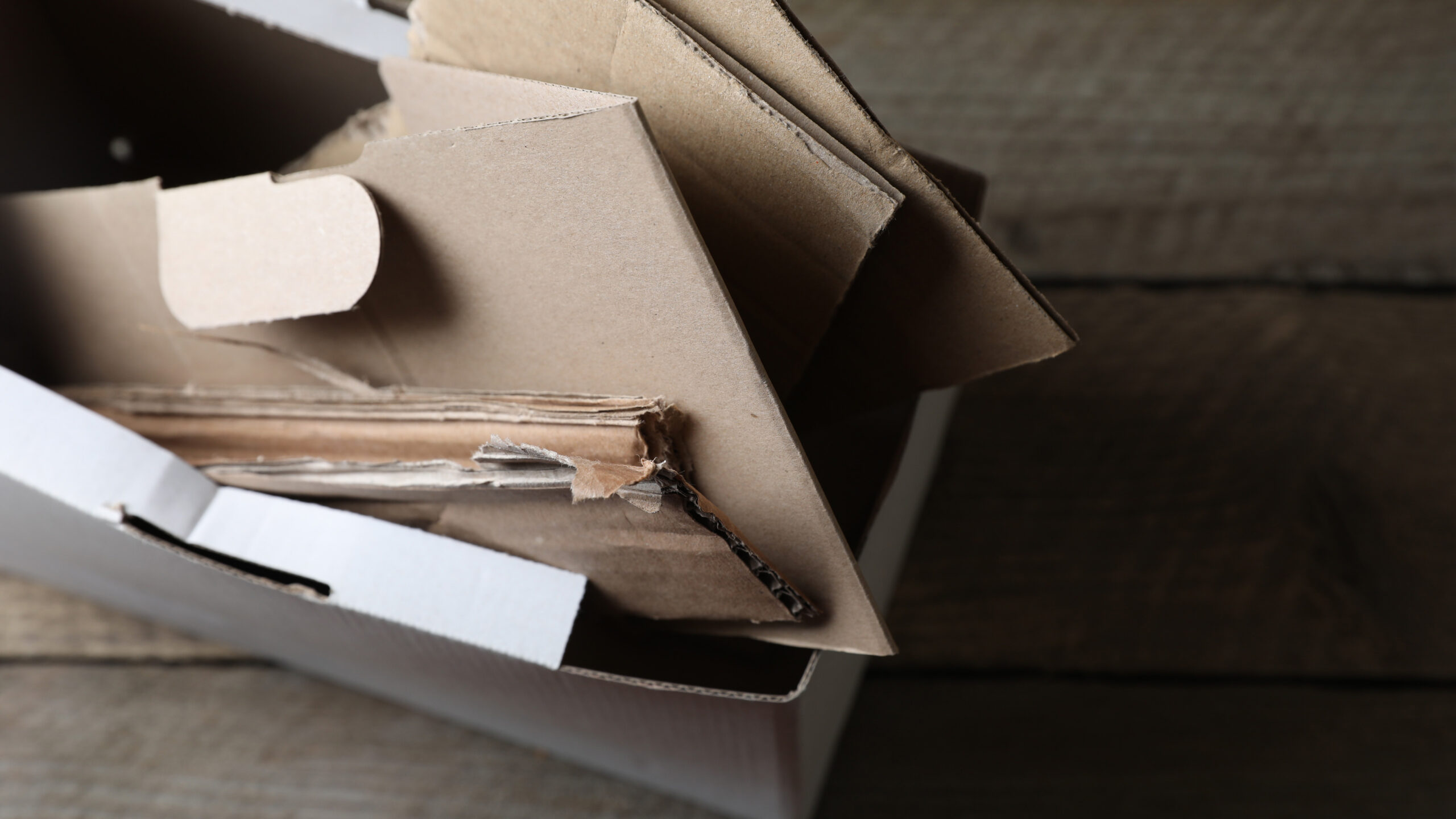 box of waste paper on wooden table view from above